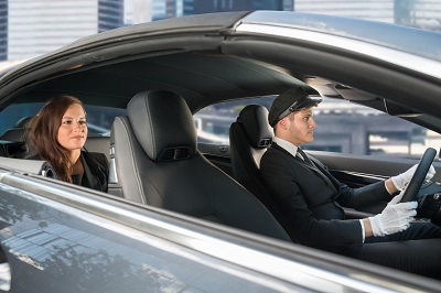 image of woman and driver in car