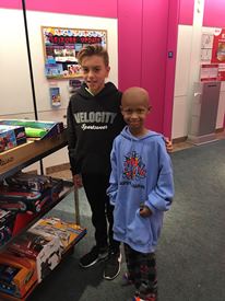 a young boy standing in front of a store