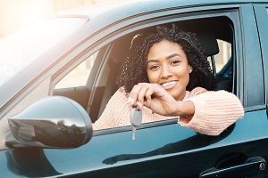 young female driver holding keys to car