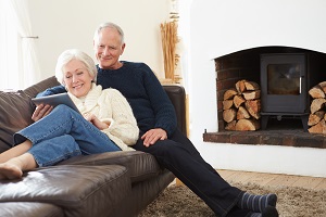 older couple sitting on couch looking at tablet