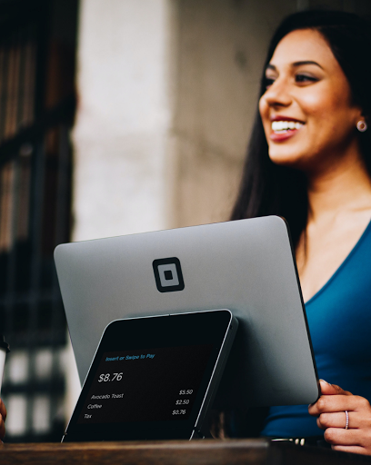 a woman standing in front of a laptop